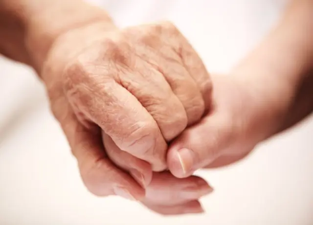 Getting Started A caregiver holds an older person's hands to comfort them