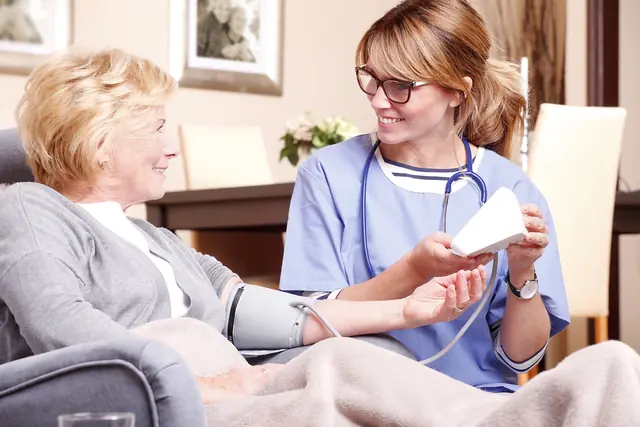 Skilled Nursing A nurse checks an older woman's blood pressure in her living room