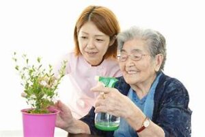 Nurse and an old woman watering a plant